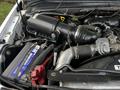 Close-up of the engine compartment of a 2009 Ford F-550 showing the air intake system battery and various engine components