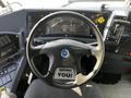 Interior dashboard of a 2022 Blue Bird Vision showing a steering wheel gauges and controls with a floor mat that says Serving You