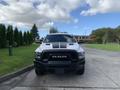 A white 2021 RAM 1500 with a prominent black hood and black grille facing the viewer