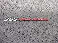A close-up of a 1974 Dodge Challenger badge reading 360 FOUR-BARREL with water droplets on the surface