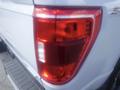 Close-up of the rear tail light of a 2022 Ford F-150 showing the red and white lens design and reflective elements