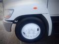 A close-up of the front wheel and fender of a 2013 Hino 308 truck showcasing the wheel design and white tire