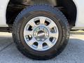 Close-up of a 2014 Ford F-250 SD wheel featuring a silver multi-spoke rim and a rugged tire with aggressive tread pattern