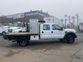 A 2009 Ford F-450 Super Duty truck with a flatbed and utility box, featuring a crew cab and dual rear wheels