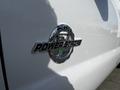 A close-up of the chrome Power Stroke badge on a white 2011 Ford F-450 SD showcasing its diesel engine branding