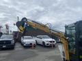 A 2024 AGT Industrial H13R Mini Excavator with a large digging arm and bucket attached in the foreground