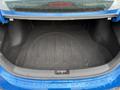 The trunk of a 2021 Kia Forte showing a dark fabric interior with a smooth floor and a raised section in the middle
