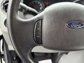 Close-up of the steering wheel of a 2014 Ford Econoline showing the Ford logo and two buttons labeled ON and OFF