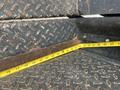 A close-up view of a 2008 Mitsubishi Fuso FE180's metallic floor with a measuring tape laid across a diamond-plate surface