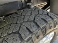 Close-up of a rugged tire from a 2022 RAM 3500 showcasing a deep tread pattern and visible wear indicating off-road use