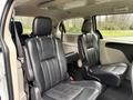 Interior of a 2017 Dodge Grand Caravan featuring two front seats with black leather upholstery and armrests