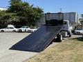 A 2018 International DuraStar tow truck with a lowered flatbed ramp ready for loading vehicles