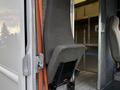 A gray fabric seat from a 2012 Ford Econoline partially turned towards an open doorway inside the vehicle