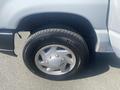 A close-up view of the front tire and wheel of a 2009 Ford Econoline showcasing the silver rim and Kumho tire tread