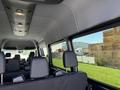 Interior view of a 2023 Mercedes-Benz Sprinter showing rows of black seats and overhead lighting