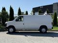 White 2011 Ford Econoline van parked with a ladder rack on its roof and side door open