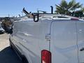 A 2016 Ford Transit van with a white exterior and a roof rack visible on top