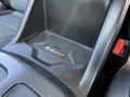 A close-up view of the center console of a 2021 Chevrolet Colorado featuring a textured storage area with control buttons and indicators