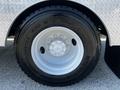 Close-up of a white alloy wheel with a black Michelin tire on a 2004 Freightliner M2 displaying the tire size and tread design