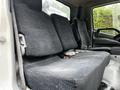 A bench seat in a cab of a 2014 Hino 195 truck with dark fabric upholstery and seatbelt attachments