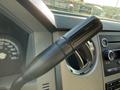 A close-up of the gear shift lever in a 2014 Ford F-550 with a black textured handle and markings for towing