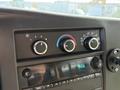 Dashboard controls of a 2020 Chevrolet Express featuring knobs for air conditioning and a digital clock display