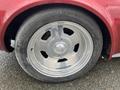 A close-up of a chrome wheel rim with five cut-out sections on a 1970 Chevrolet Corvette showcasing a wide tire