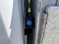 Close-up of a blue valve on a black casing attached to a 2019 Ford F-550 truck