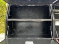 A 2016 Ford F-550 with an open black utility box showing empty shelves and no visible contents