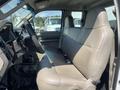 The interior of a 2008 Ford F-450 SD showing the front bench seat with beige upholstery and a simple dashboard design