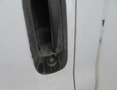 Close-up view of the door handle on a 2020 Chevrolet Express van showcasing a black plastic handle with visible wear and grime
