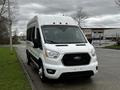 2021 Ford Transit van with a white exterior and distinctive front grille positioned on a road