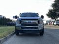 A 2018 Ford F-450 SD with a metallic silver finish facing the viewer showcasing its prominent grille and headlights