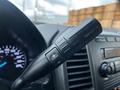 A close-up of the gear shift lever in a 2019 Ford F-550 with buttons marked for tow haul and a plus and minus symbol for gear selection