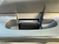 Close-up of a door handle in a 2006 Ford F-650 featuring a textured gray plastic surface and a rectangular black insert for easy gripping