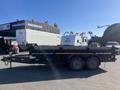 A 2024 Southland 18 Foot Dump Trailer featuring a black exterior and a dual axle design with a front familiar hitch for towing