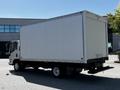 A 2007 GMC W3500 box truck is parked with its white cargo area facing away from the camera showcasing a flatbed and a simple tailgate design