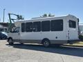 A 2017 Chevrolet Express bus with large windows and a white exterior parked on a lot