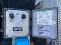 A metal control panel featuring two knobs labeled for electric heat control and burner heat control along with an instruction sheet detailing operational guidelines and service information