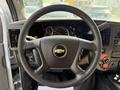 Steering wheel of a 2020 Chevrolet Express with a Chevrolet logo in the center and various controls on the side