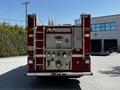 A red 2006 Emergency One Fire Truck with a rear view showing hoses and a control panel