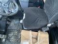 A 2016 Hyundai HL940 heavy equipment operator's seat with textured fabric and controls visible in the cab interior