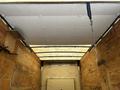 Interior view of a 2018 Ford Econoline showing a ceiling panel with a white surface and wooden walls