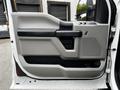 A 2017 Ford F-250 truck door panel featuring a sleek design with a mix of gray and black materials and a speaker grille near the bottom