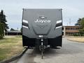 A 2021 Jayco Jay Flight travel trailer with a sleek gray and black exterior featuring the Jayco logo prominently displayed on the front