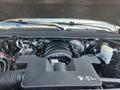 A 2016 Chevrolet Tahoe engine with a large black cover and various components including hoses and cables in the engine bay
