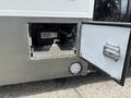 A 2020 Chevrolet Express with an open compartment showcasing a battery labeled Canada Proof inside