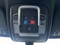A vehicle interior overhead console featuring buttons for assist and SOS functions with indicator lights and a sleek metallic trim