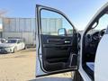 A 2023 RAM 3500 with an open driver's door showcasing the interior features including the door panel and dashboard