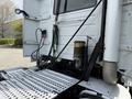 A 2012 Volvo VNL truck showcasing its rear compartment including hoses and a mounted reservoir with a metal platform